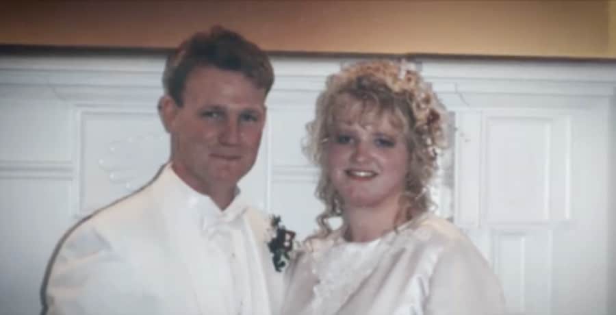 A man and woman wearing white for their wedding photo
