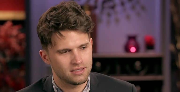 A man with brown hair looking down