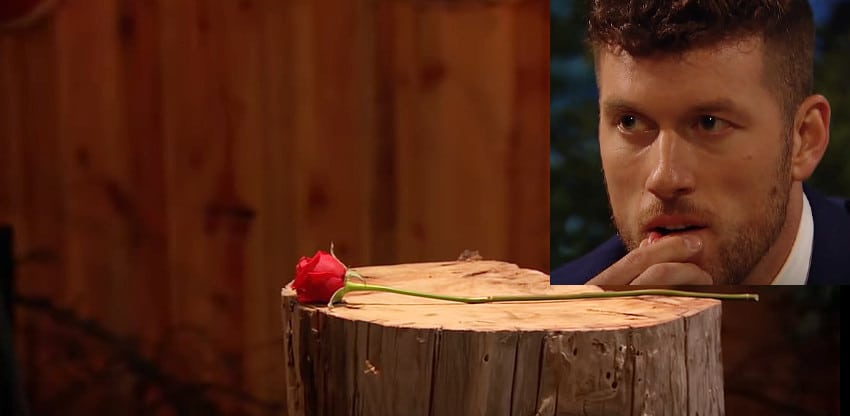 A man looking at a rose on a table