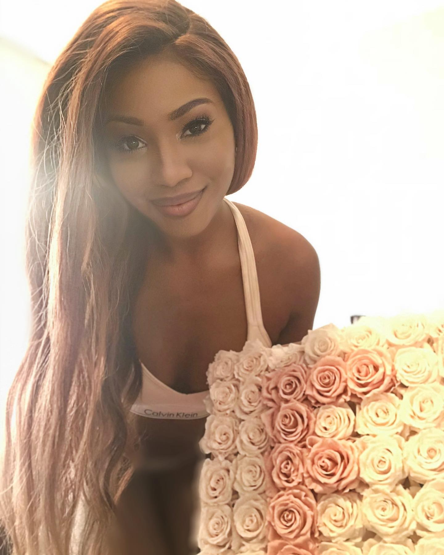 A woman in a bathing suit standing in front of roses