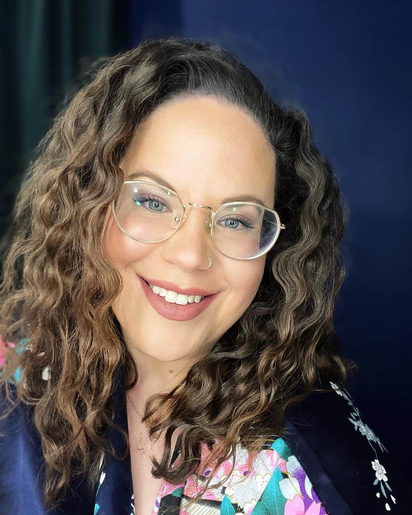 A woman with curly hair and glasses