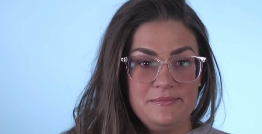 A woman with brown hair and glasses