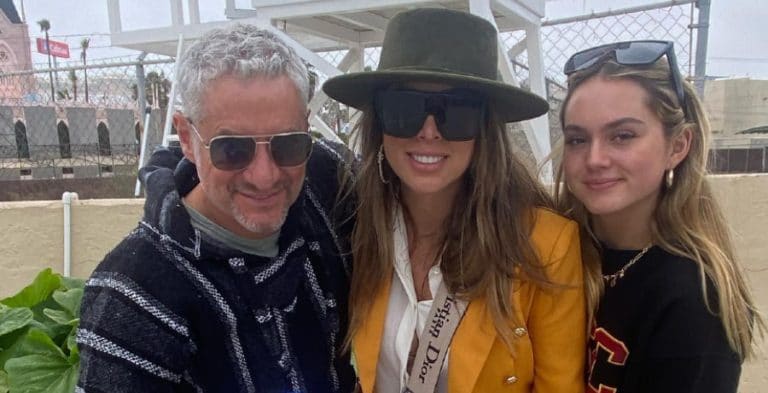 A man, woman and teenager smile for camera