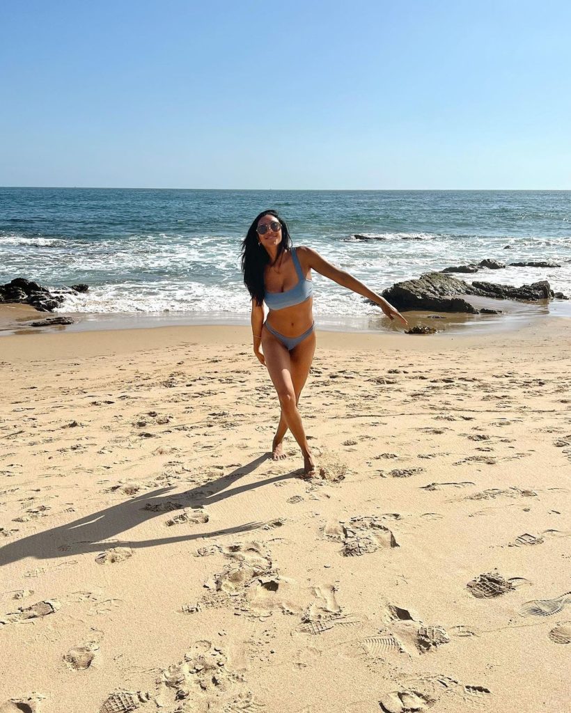 A woman wearing a blue bikini on a beach