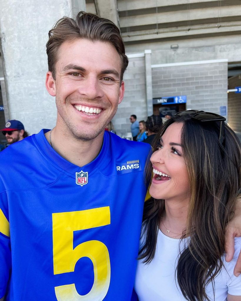 A man in a football jersey and a woman with brown hair