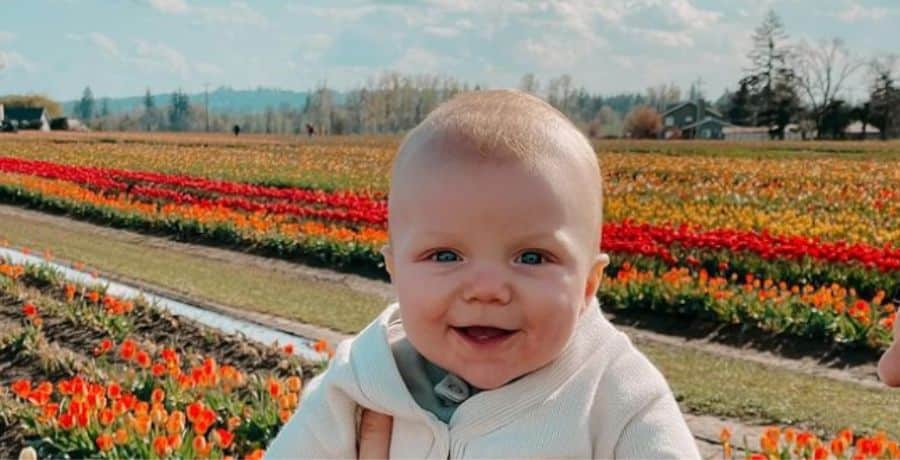 Radley Roloff in a tulip field, held up to camera by Audrey Roloff - Instagram/Audrey Roloff