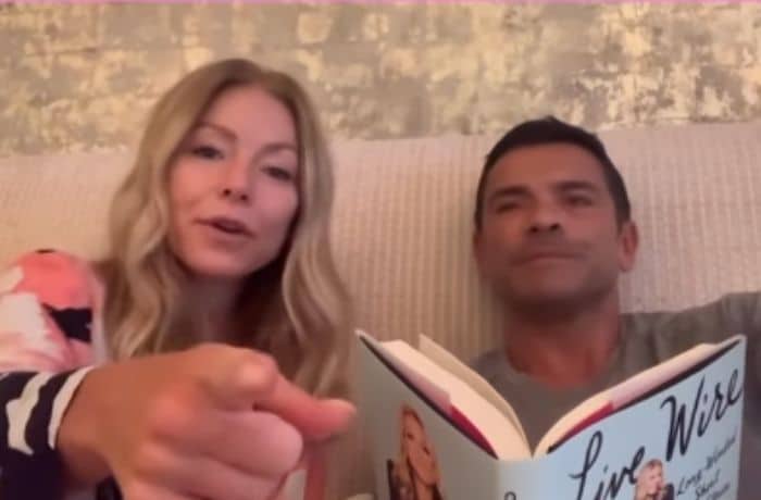 Kelly Ripa and Mark Consuelos in bed reading her memoir - Instagram/Kelly Ripa - Ryan Seacrest gets spicy video message from Mark