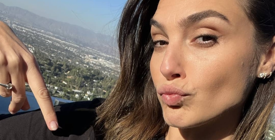 Gal Gadot puckers up in close-up selfie with a black tee.