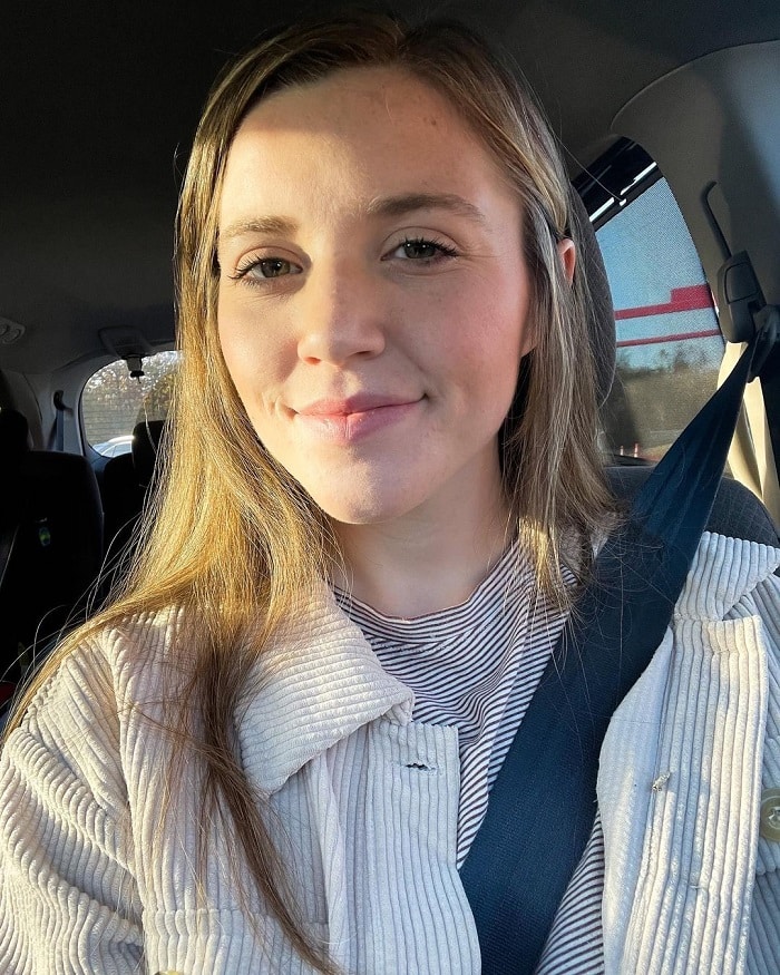 Joy Forsyth smiles in sun-kissed car selfie. 