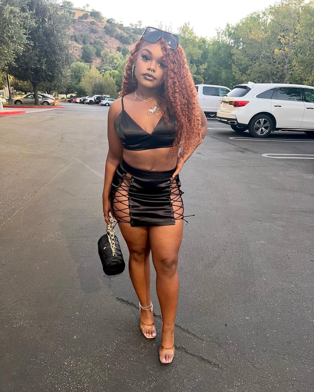 Kiaya Elliott shows off sexy curves in black mini skirt and bustier.