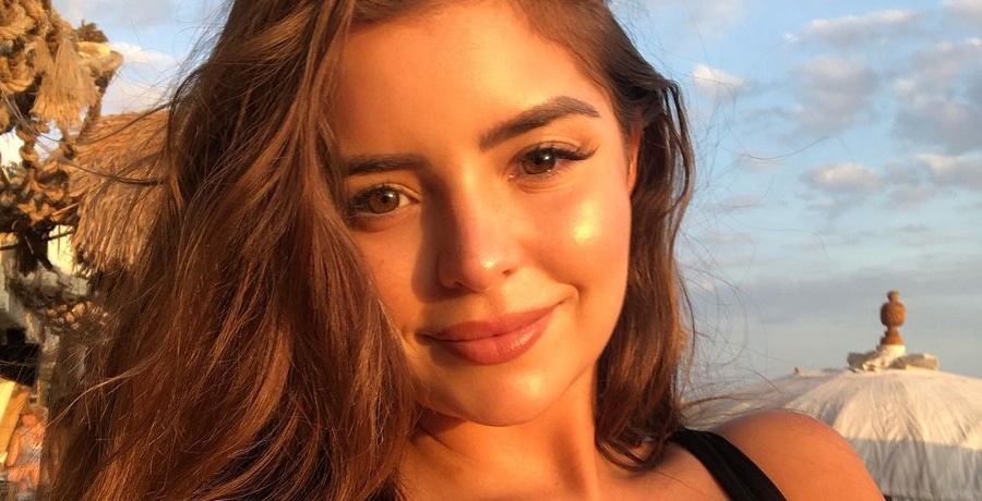 Demi Rose snaps a sun-kissed selfie in a strappy black top.