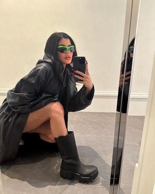 Kylie Jenner takes a mirror selfie in a black leather jacket and chunky boots.