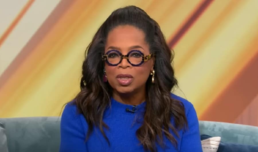 Oprah Winfrey Wears Blue Blouse & Black Eyeglasses [Source: YouTube]