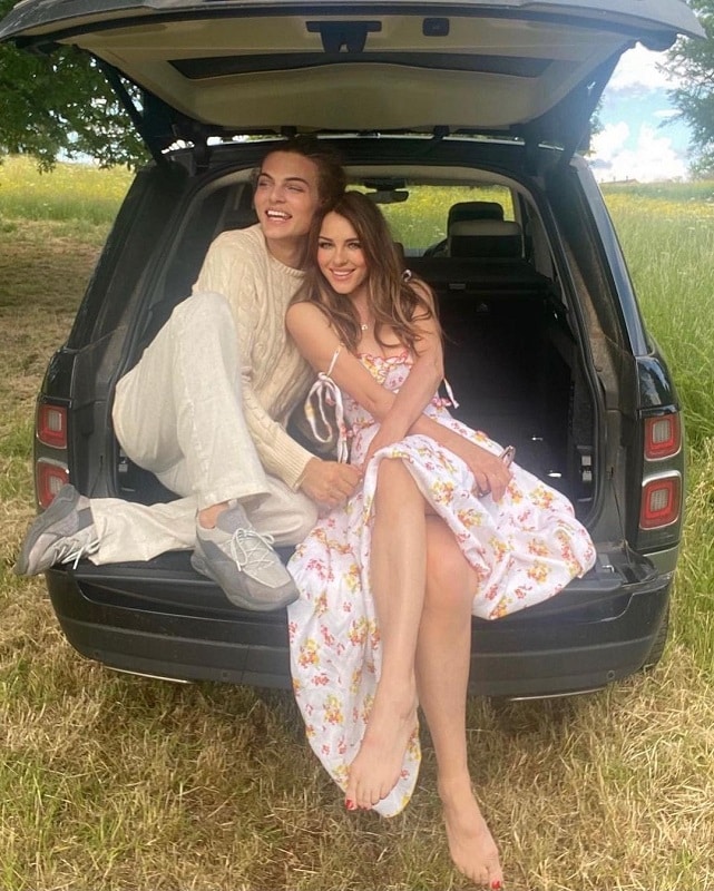 Elizabeth Hurley, 58, shows off her supple legs in a strappy sundress while sitting in the trunk of a car with her lookalike son, Damian Hurley, 21.[Credit: Elizabeth Hurley/Instagram]