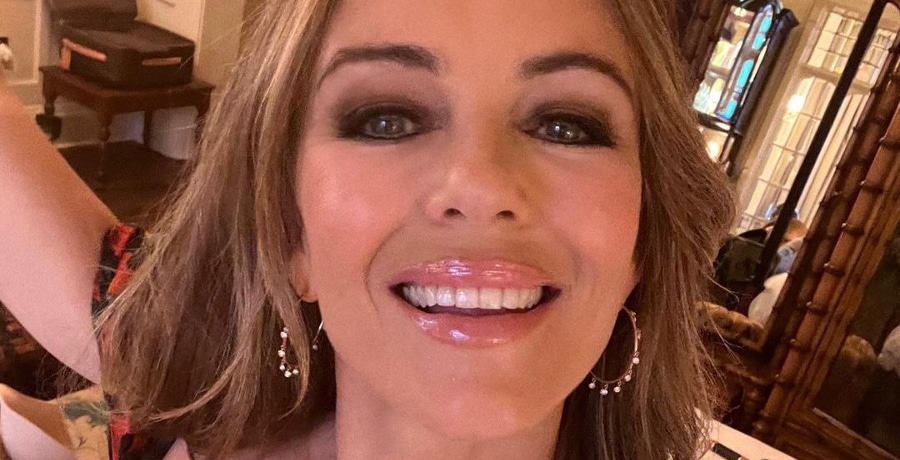 Elizabeth Hurley smiles big in close-up selfie with stone-encrusted large hoop earrings.