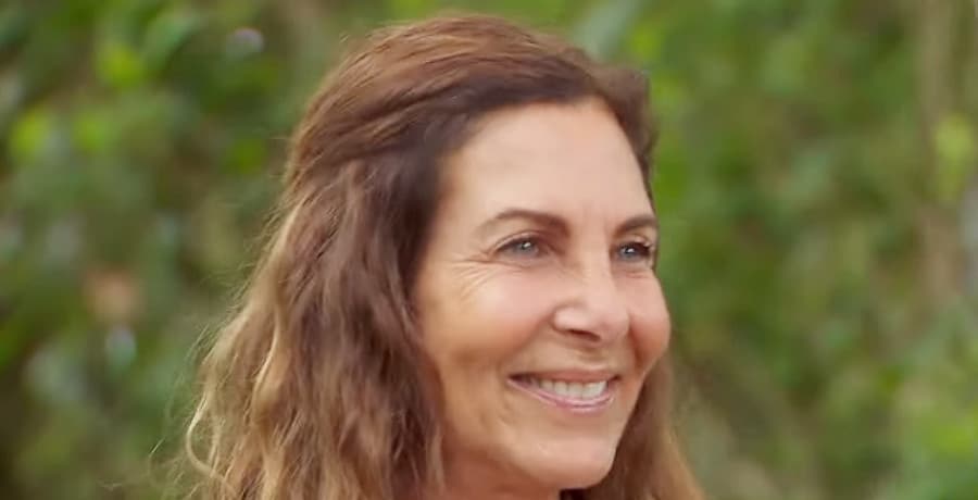 A woman with brown hair smiles at the camera.