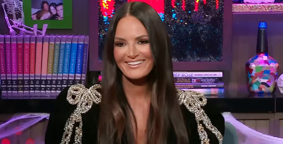 A woman with long brown hair wearing a black shirt