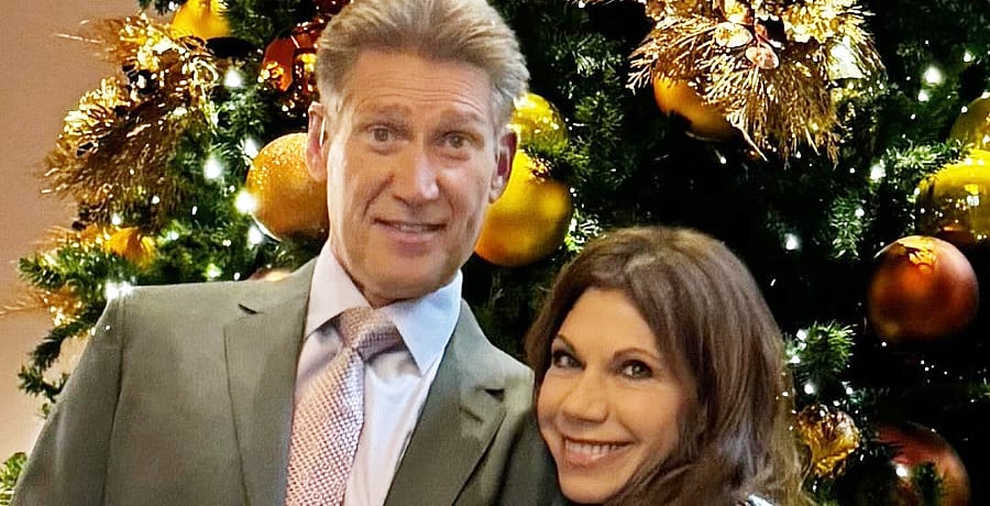 A man and a woman standing in front of a Christmas tree.