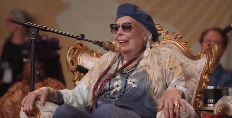 An older woman sitting down in front of a microphone.