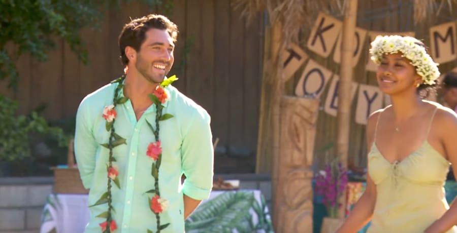 A man in a blue shirt and a woman with a white flower crown