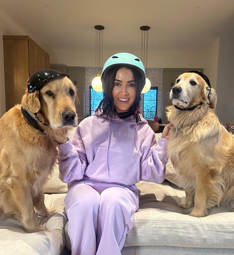 A woman and her two dogs wearing helmets