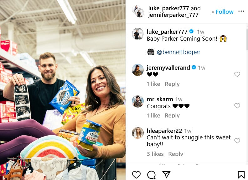 A baby announcement. A man and a woman in a grocery story with a cart full of baby items.