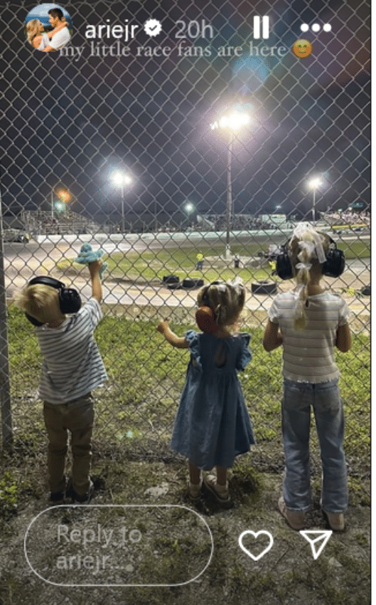three young kids watching a car race