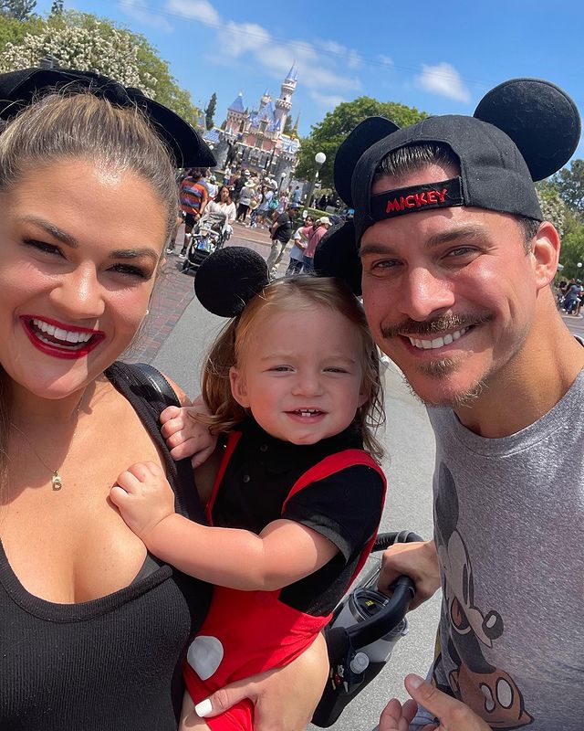 A man and a woman with their son between them. All three are wearing Mickey Mouse ears