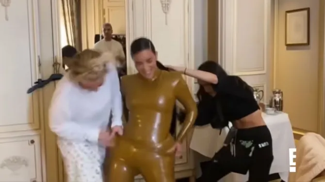 Kim Kardashian is shown struggling to get into her 2020 Paris Week latex outfit. - E! Networks