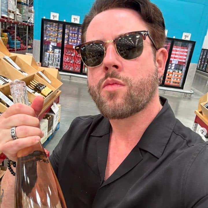 Whitney Thore's brother Hunter posing with a bottle of alcohol