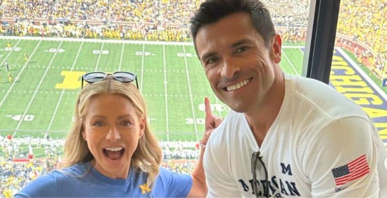 Kelly Ripa and Mark Consuelos posing for a photo at a football game (1)